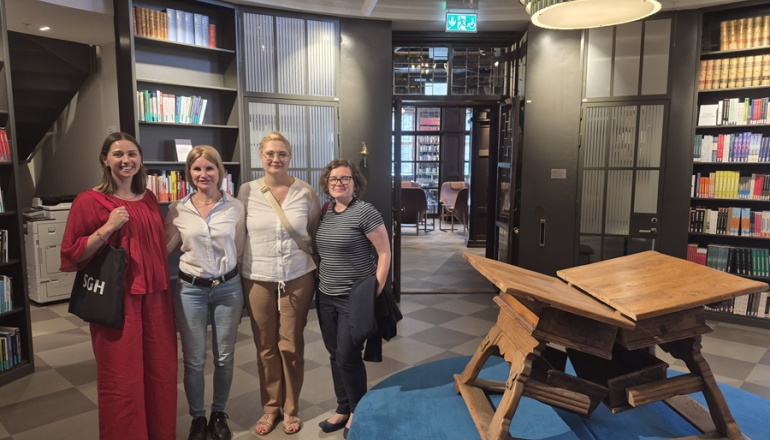 zdjęcie czterech kobiet na uczelni, w środku biblioteki
