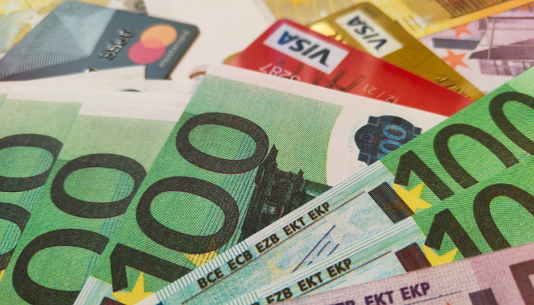 banknoty i karty kredytowe rozłożone na stole