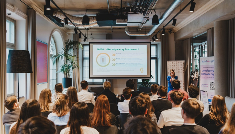 zdjęcie zrobione z tyłu sali przedstawiające studentów słuchających panelu