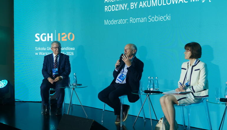 trzy osoby rozmawiają na scenie na panelu