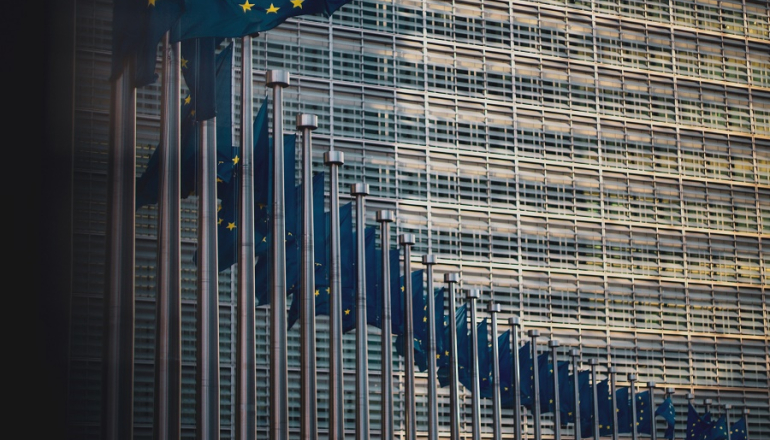 flagi unijne na tle budynku KE w Brukseli