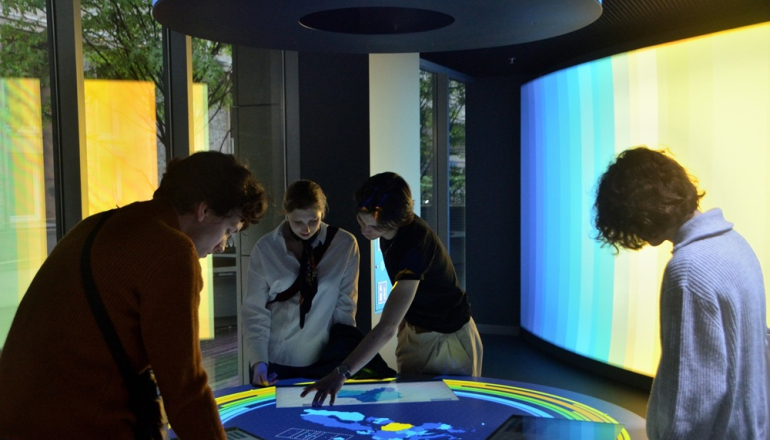 trzy osoby nad podświetloną mapą