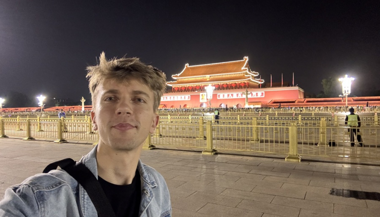 zdjęcie mężczyzny na tle oświetlonej pagody