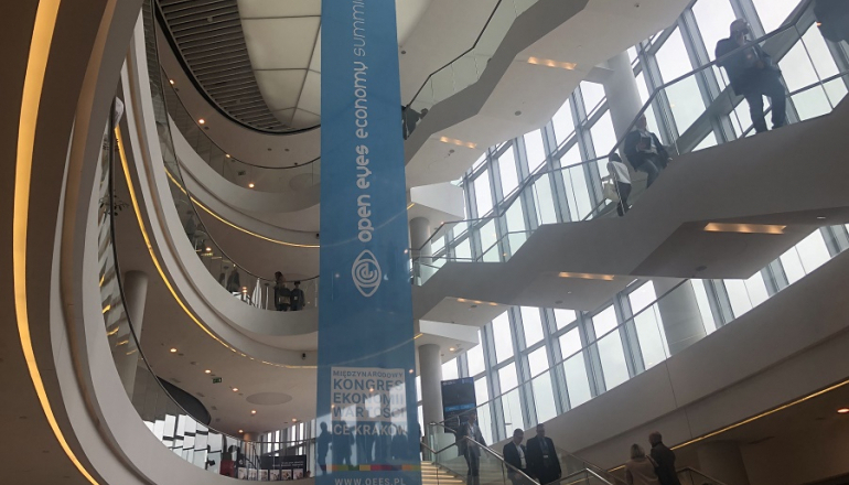 wiszący banner Open Eyes Economy Summit 2023 w hallu obiektu konferencyjnego