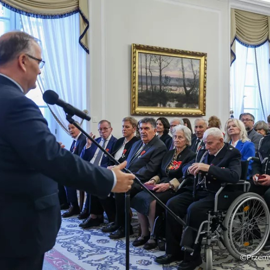na zdjęciu mężczyzna przemawiający do osób siedzących w sali 