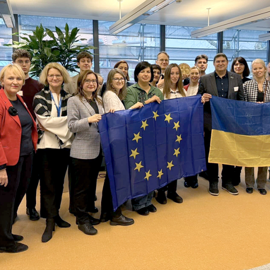 Grupa ludzi trzymająca flagi UE i Ukrainy