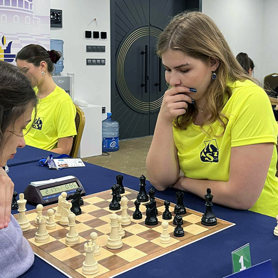 Kobieta przy stole z rozłożonymi szachami