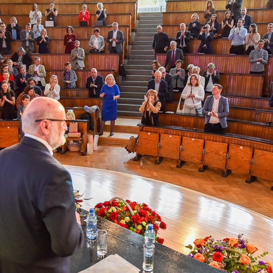 mężczyzna stojący przed uczestnikami konferencji w auli spadochronowej