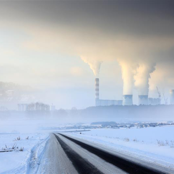 zaśnieżone pole, w oddali dymiące kominy