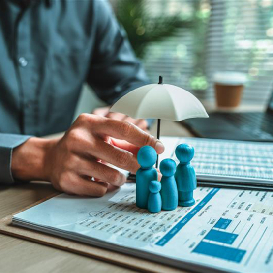 otwarte zeszyty, ludziki i dłoń człowieka trzymająca mały parasol