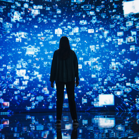 kobieta stojąca przed ekranami świetlnymi