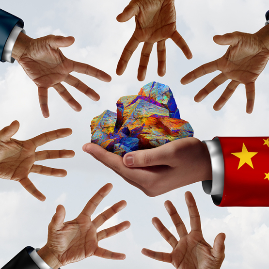 dłoń trzymająca kolorowe kamienie i wokół inne dłonie wyciągnięte w stronę tych kamieni