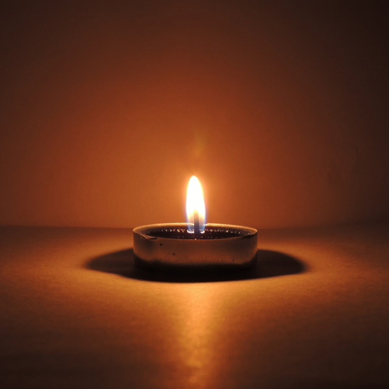 płonąca świeczka w ciemnym pomieszczeniu