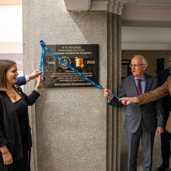 kilka osób odsłania tablicę pamiątkową 
