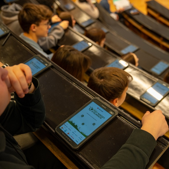 młodzi rozwiązują test wiedzy na jednej z uczelnianych auli