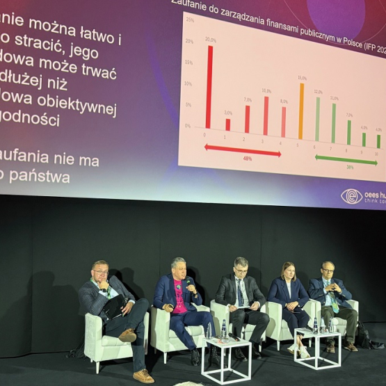 kilka osób siedzi na scenie podczas konferencji 