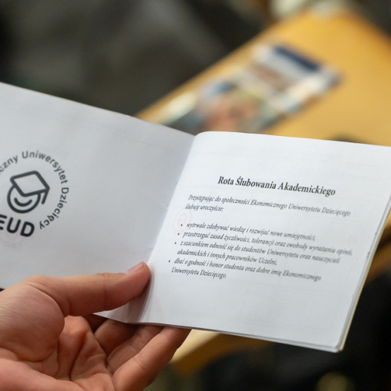 zdjęcie trzymanej w dłoni książeczki z tekstem ślubowania 