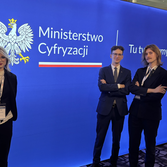 dwóch młodych mężczyzn i kobieta na tle granatowej ścianki
