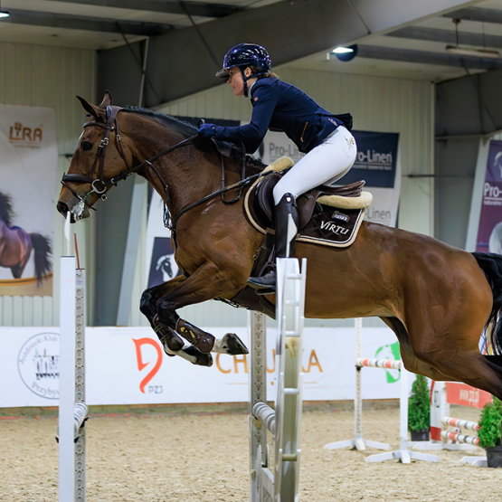 kobieta na koniu skaczącym przez przeszkody