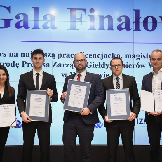 piecioro osób prezentuje dyplomy na gali GPW; w tle na ekranie wyświetlony napis: "Gala Finałowa konkursu"