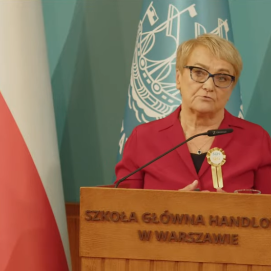 zdjęcie przemawiającej kobiet, z lewej strony flaga Polski