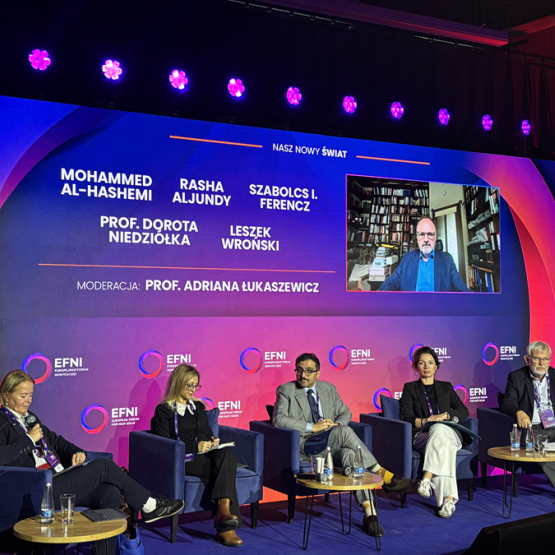 kilka osób siedzi na scenie podczas panelu