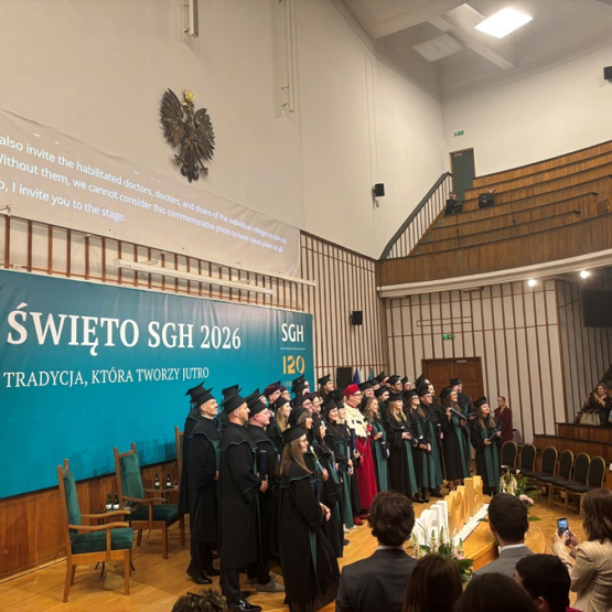 doktorzy i doktorzy habilitowani podrzucają w górę birety podczas uroczystości na uczelni