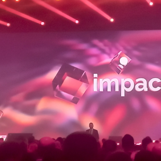 scena oświetlona na różowo, napis Impact