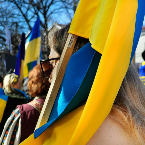 ludzie niosą ukraińskie flagi podczas demonstracji