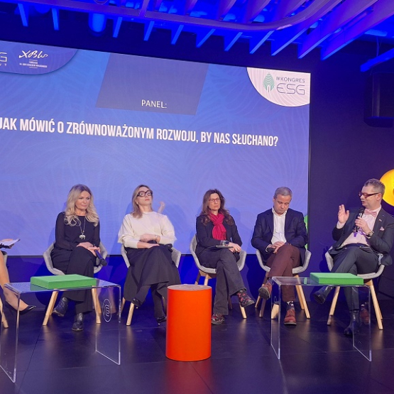 kilka osób siedzi na scenie i dyskutuje podczas panelu