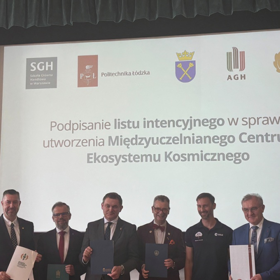 pięciu mężczyzn po podpisaniu dokumentu, w tle slajd z napisem