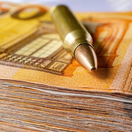 zdjęcie naboju/ łuski po naboju na stosie banknotów