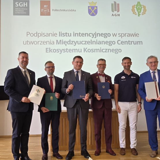 pięciu mężczyzn po podpisaniu dokumentu, w tle slajd z napisem