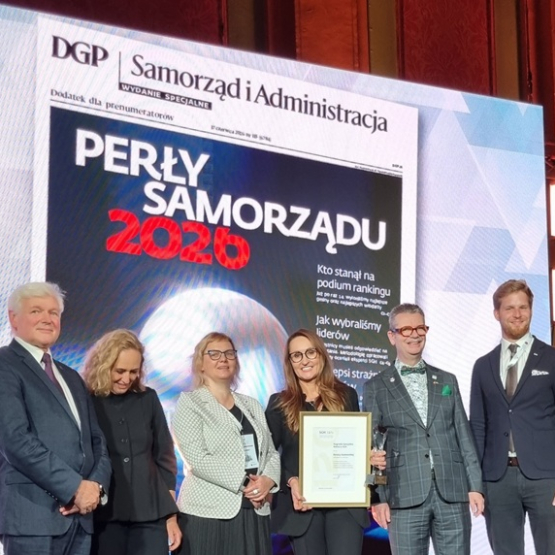 kilka osób na scenie, w tle wyświetlany napis