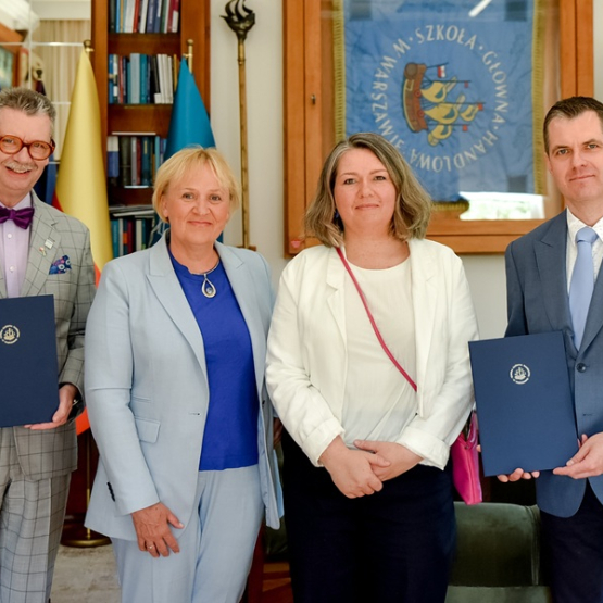 dwie kobiety i dwóch mężczyzn w gabinecie po podpisaniu porozumienia