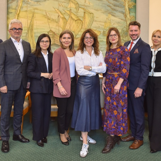 grupa osób pozuje do zdjęcia w sali uczelni