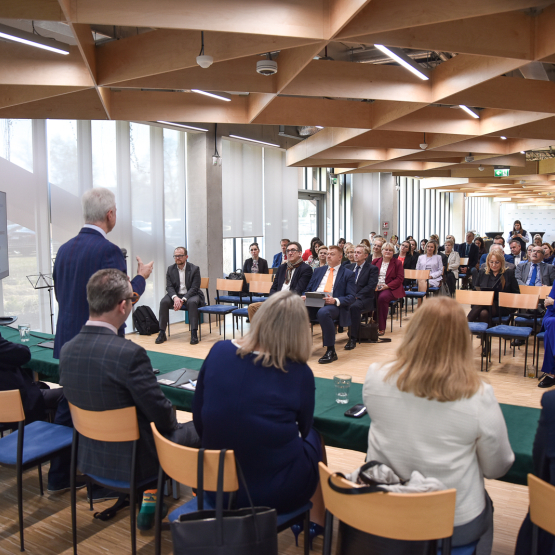 zdjecie zrobione z perspektywy stołu prezydialnego - cała sala pełna ludzi na spotkaniu