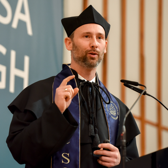 zdjęcie mężczyzny w todze na tle napisu SGH