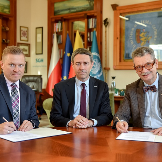 trzech mężczyzn podpisuje dokumenty