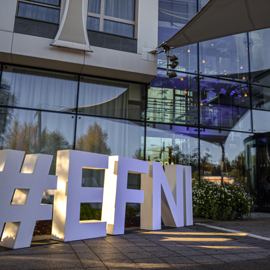 duże białe litery ułożone na ziemi układające się w napis: #EFNI