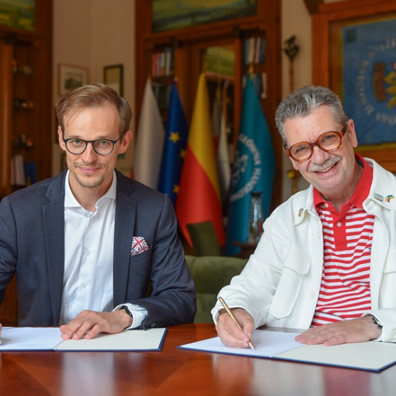 dwóch mężczyzn podpisuje umowę