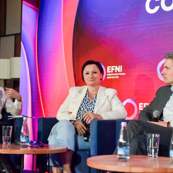 trzy osoby rozmawiają podczas panelu