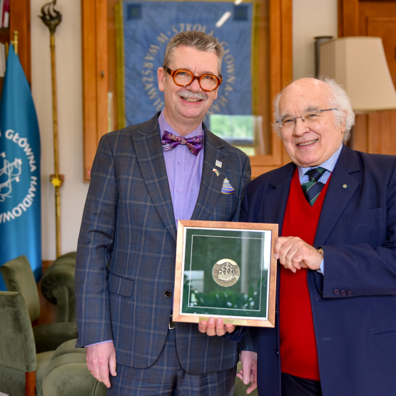 dwóch mężczyzn w gabinecie pokazuje medal za zasługi 