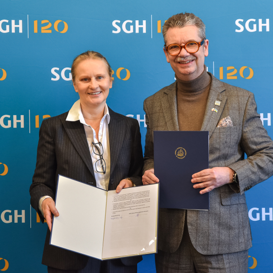 mężczyzna i kobieta pozują do zdjęcia z podpisanym porozumieniem