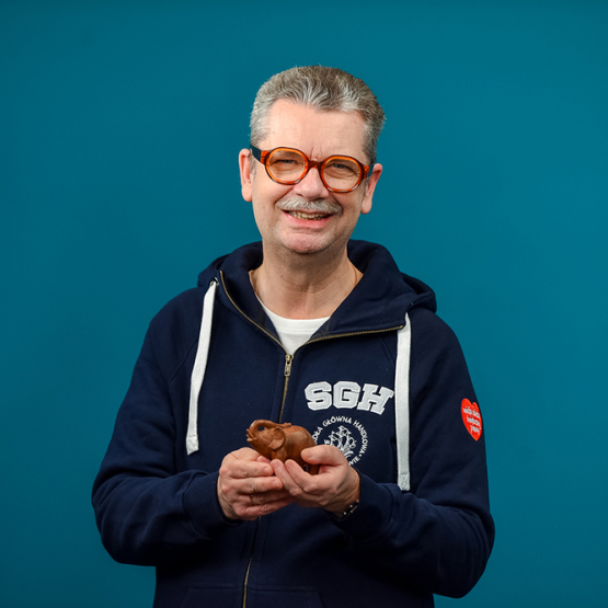 mężczyzna w bluzie SGH z logo WOŚP trzymający słonia