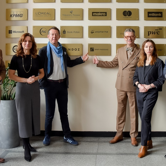 na zdjęciu kilkoro osób pod tablica Klubu artnerów