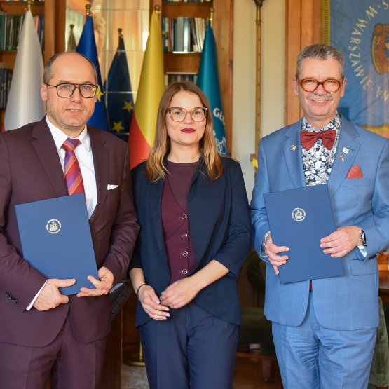 trzy osoby w gabinecie po podpisaniu porozumienia