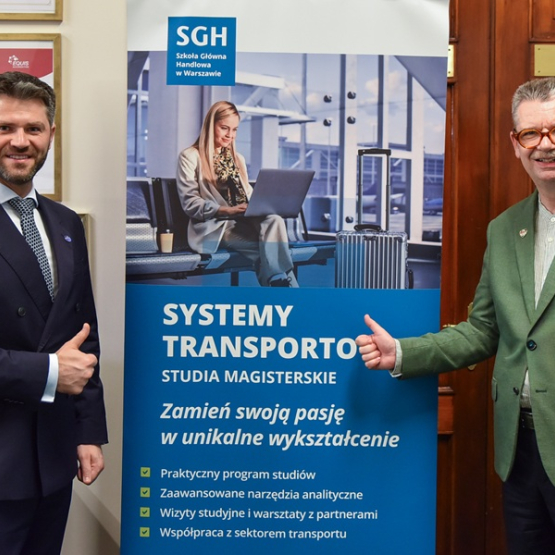 dwóch mężczyzn stoi przy rollupie