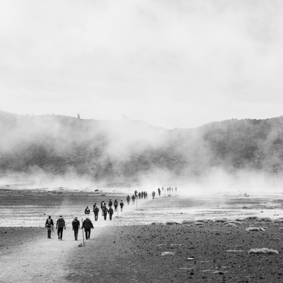 zdjęcie czarno-białe; ludzie w oddali idący po plazy