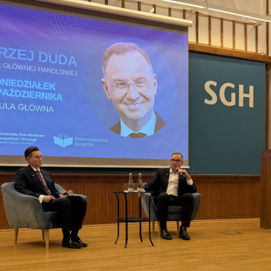 dwóch mężczyzn rozmawia ze sobą na scenie, z tyłu wyświetlony ekran
